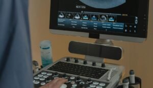 A healthcare professional using an ultrasound machine in a clinical setting.