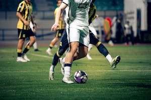 Close-up of soccer players in action during a match at an outdoor stadium.